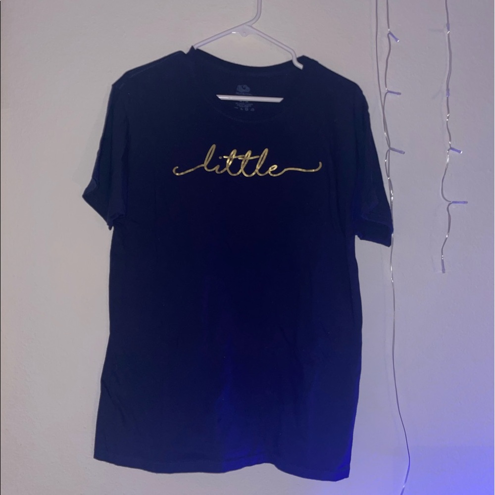 navy blue shirt with gold “little” sorority